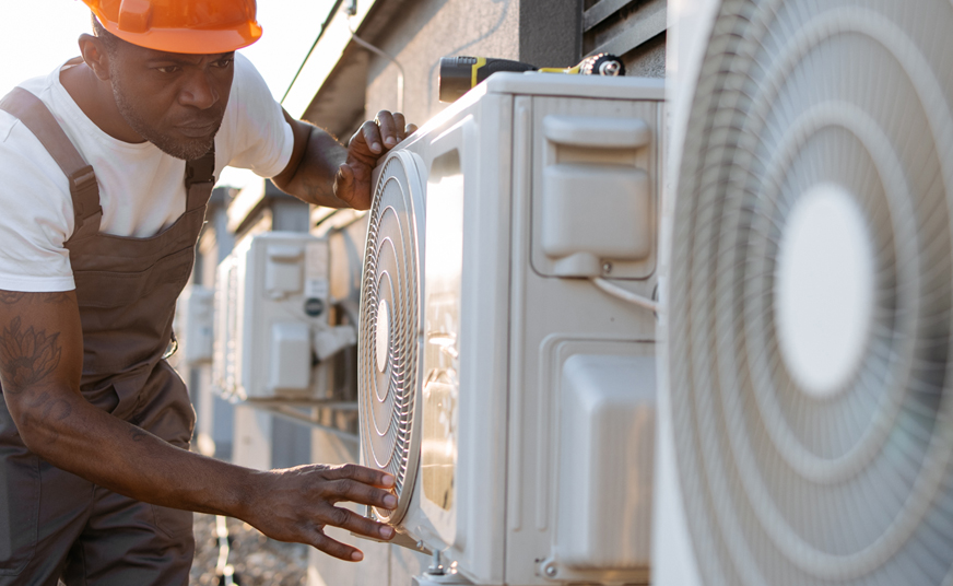 Picture of a man servicing a row of heat pumps